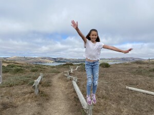 Natalia posing in front of a beautiful view of Bodega Bay that looks like a painting